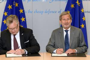 The Director of OSCE Office for Democratic Institutions and Human Rights (ODIHR) Michael Georg Link (l) and EU Commissioner for European Neighbourhood Policy and Enlargement Negotiations Johannes Hahn (r) sign an agreement launching a new project to support democratic elections in the Western Balkans in Brussels, 27 June 2017. (EC - Audiovisual Service/Georges Boulougouris)