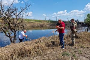 Експерти відбирають проби води в районах Херсонської області, постраждалих від руйнування дамби Каховської ГЕС.  (ОБСЄ)