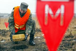 An Ukrainian Emergency Ministry officer neutralizes an unexploded shell during an exercise near Bila Tserkva, 100km (62 miles) south of Ukrainian capital Kiev, 17 November 2005. (REUTERS/STR New)