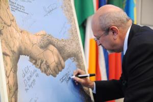 OSCE Secretary General Lamberto Zannier signing the poster with the winning design of the joint OSCE-eYeka crowdsourcing competition on security and climate change, during the OSCE Security Days event on climate change and security, Vienna, 28 October 2015.

 (OSCE/Micky Kroell)