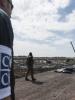 An OSCE Monitor looks on as body bags are arranged on the side of the road by the MH17 crash site. (OSCE/Evgeniy Maloletka)