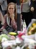 A woman reacts as she stands near bouquets of flowers in tribute to victims outside "Le Petit Cambodge" restaurant, one of the sites of the deadly attacks in Paris, 17 November 2015.  (REUTERS/Benoit Tessier)