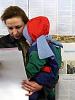 A woman holds a child as she reads a ballot during the Ukrainian parliamentary elections, in Kyiv, 26 March 2006. (OSCE/Urdur Gunnarsdottir)